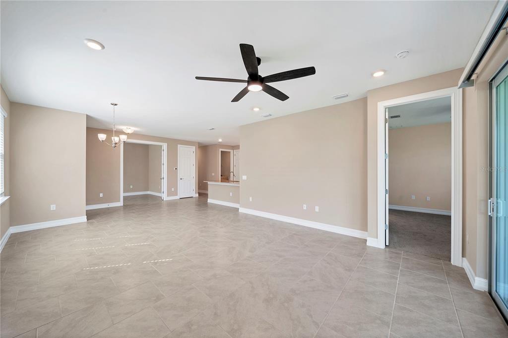 An open-concept living area with beige walls, tile flooring, a ceiling fan, and recessed lighting — 305 IBIZA LOOP, VENICE, FL