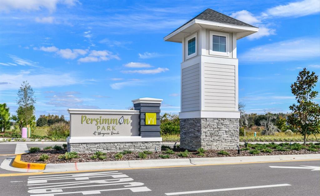 A stone and white siding monument sign marks the entrance to Persimmon Park at Weygass Ranch — 28789 SEEDLING STREET, WESLEY CHAPEL, FL
