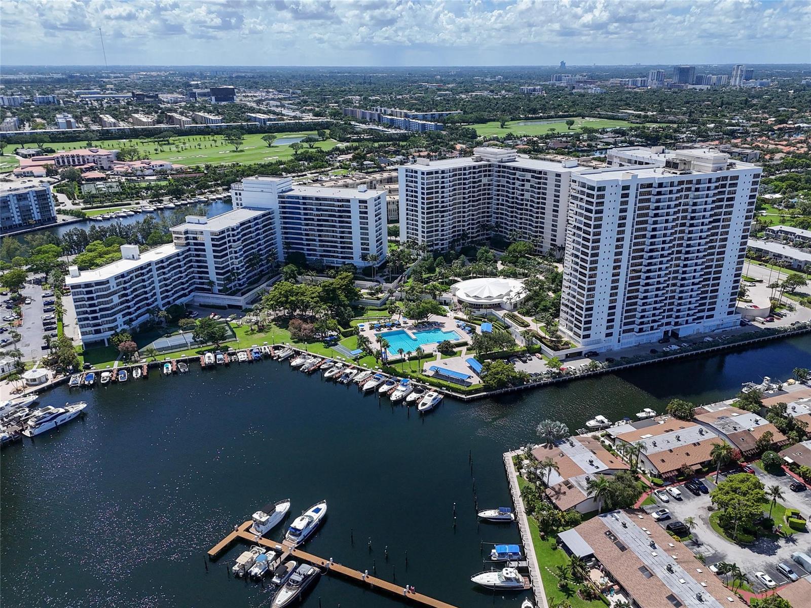 An aerial view shows a large apartment complex with a pool, marina, and docked boats — 2500 PARKVIEW Drive # 1710, Hallandale Beach FL 33009, HALLANDALE BEACH, FL