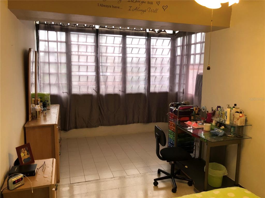 A bedroom features a tiled floor, a glass desk, and a large window with curtains — 274 CALLE URUGUAY UNIT 202, SAN JUAN, PR