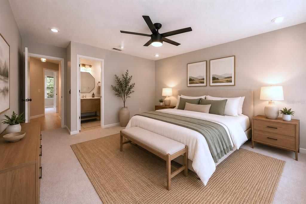 A bedroom features a king bed, a ceiling fan, a jute rug, and an attached bathroom — 641 MAPLE OAK CIRCLE UNIT 101, ALTAMONTE SPRINGS, FL