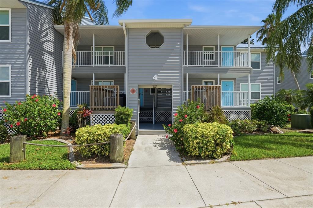 A two-story gray apartment building with balconies and a central entrance walkway — 4410 WARREN AVENUE UNIT 412, PORT CHARLOTTE, FL