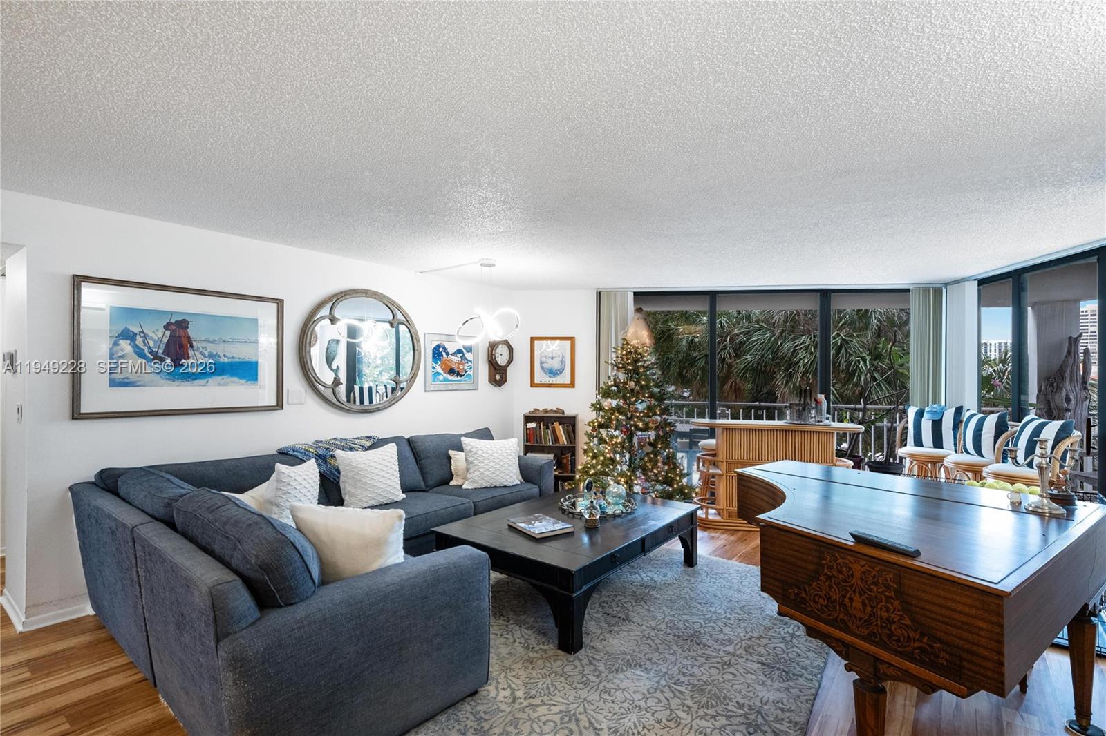 A living room features a blue sectional sofa, a grand piano, and a Christmas tree — 4000 Towerside Ter # 301, Miami FL 33138, MIAMI, FL