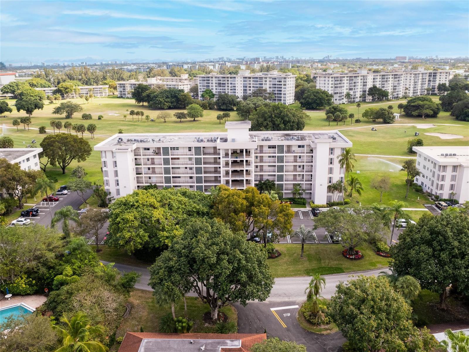 An aerial view shows a multi-story apartment building surrounded by a golf course and trees — 2850 N Palm Aire Drive # 601, Pompano Beach FL 33069, POMPANO BEACH, FL