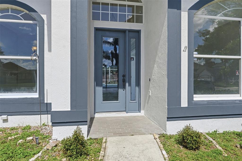 A front entryway features a blue door with a glass panel and a side light — 12714 TOPSFIELD DRIVE, ORLANDO, FL