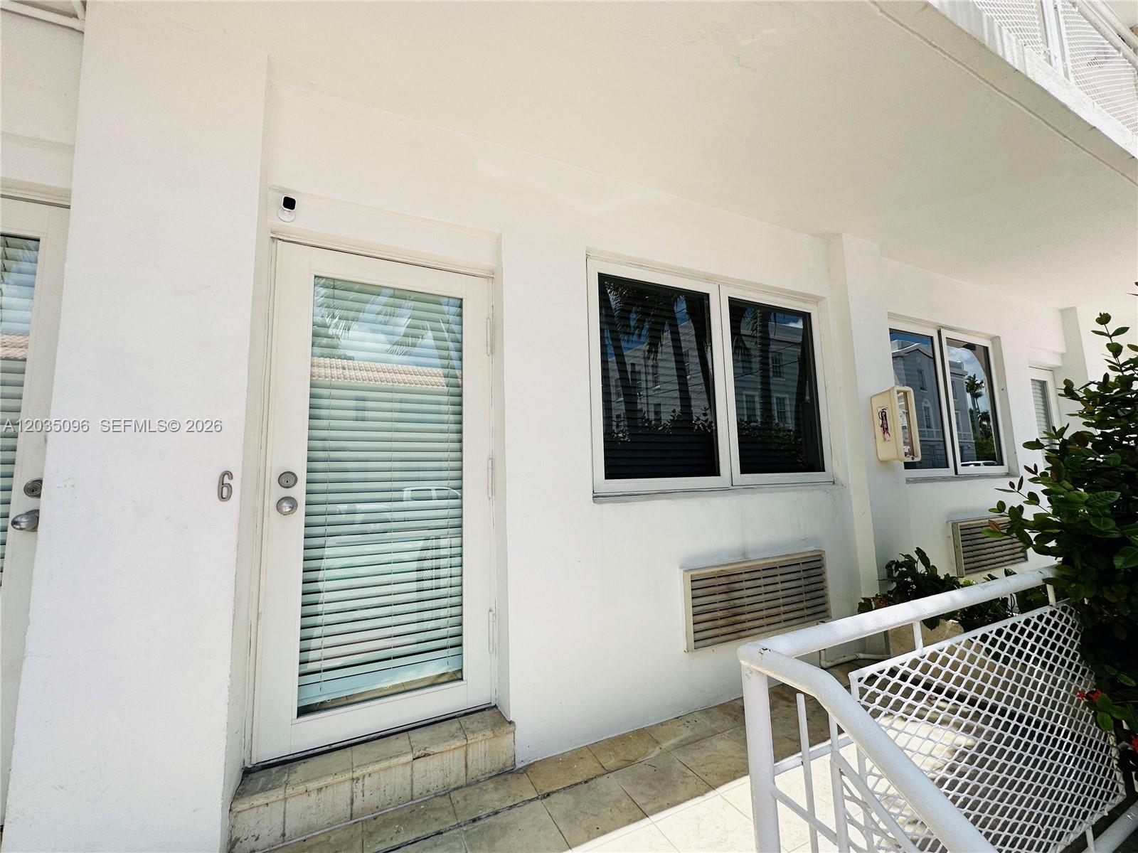 A white exterior wall features a glass-paneled door labeled six and two windows — 745 13th St # 6, Miami Beach FL 33139, MIAMI BEACH, FL