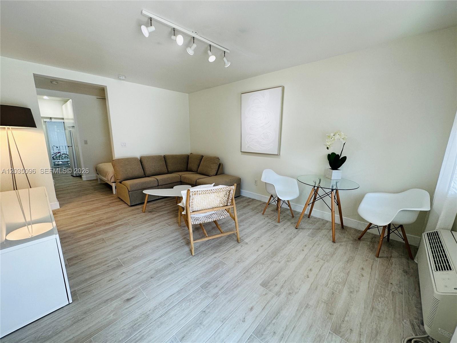 A living room features a sectional sofa, a glass dining table, and light wood flooring — 745 13th St # 6, Miami Beach FL 33139, MIAMI BEACH, FL