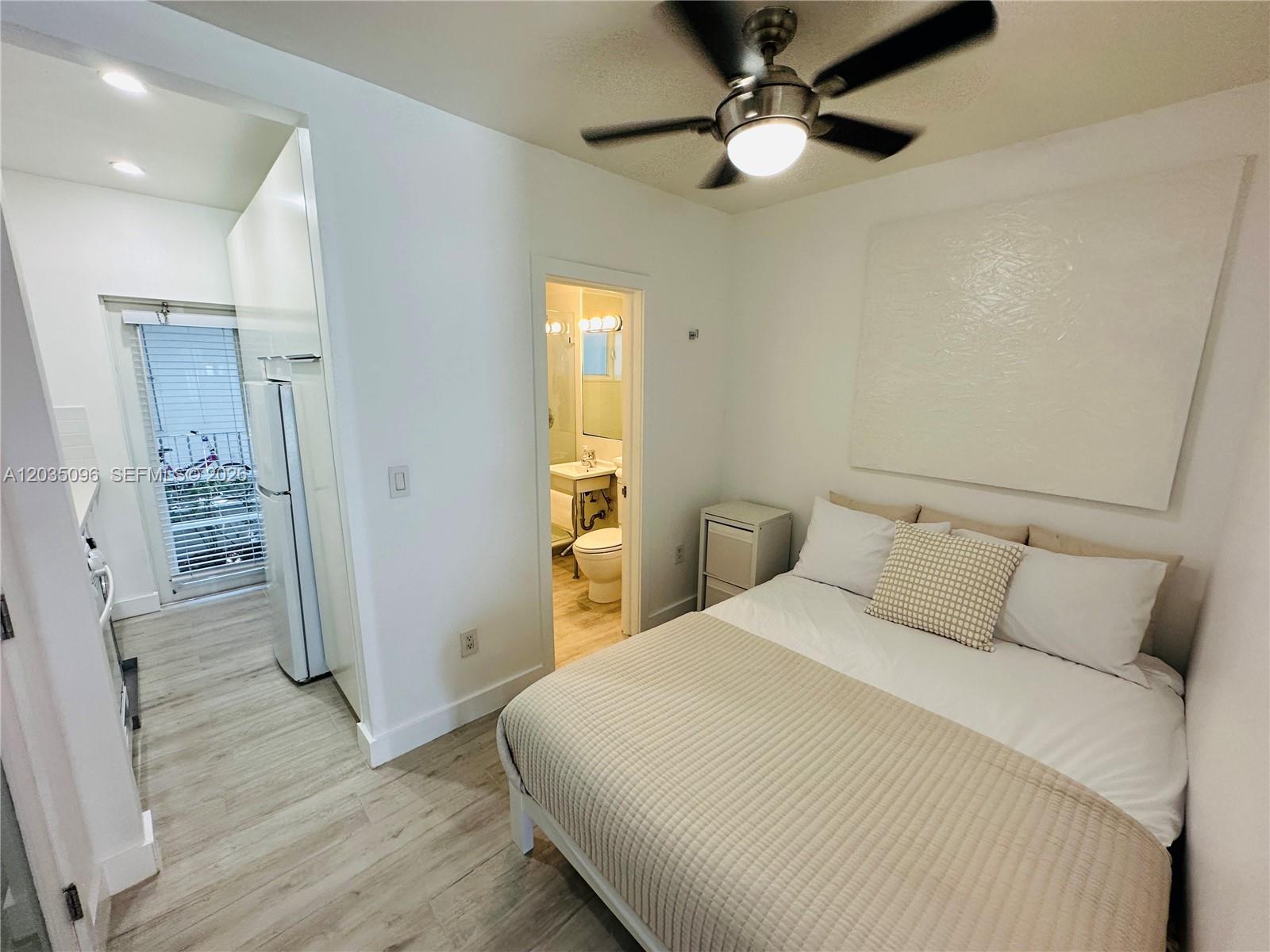A bedroom with a ceiling fan, a bed, and an adjacent bathroom and kitchen area — 745 13th St # 6, Miami Beach FL 33139, MIAMI BEACH, FL