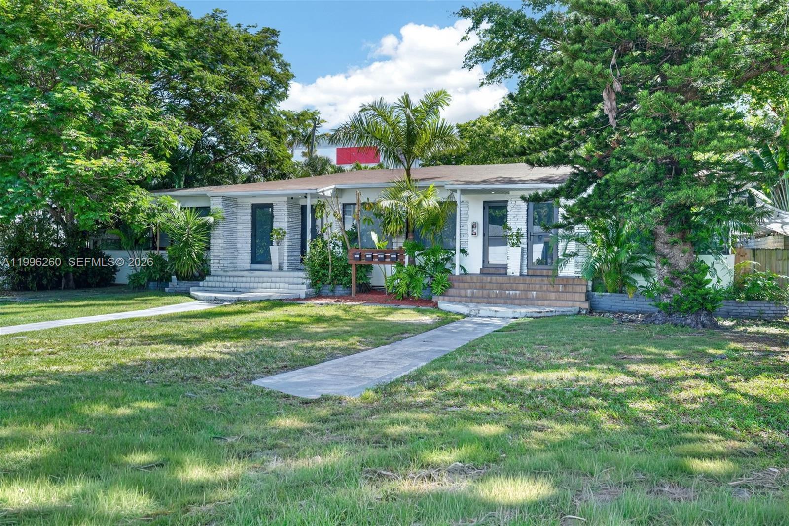 A single-story house with two front entrances, stone accents, and a large front lawn — 7811 NE 10th Ct, Miami FL 33138, MIAMI, FL