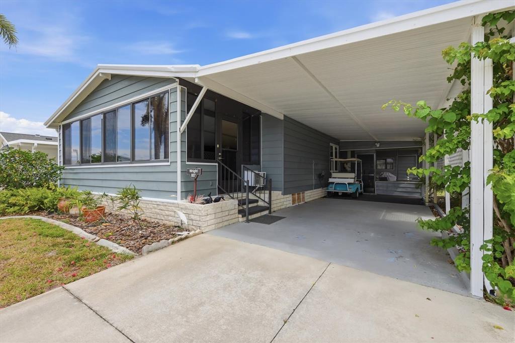 A blue mobile home with a carport, a golf cart, and a small front porch — 807 SEABROOKE DRIVE, ENGLEWOOD, FL