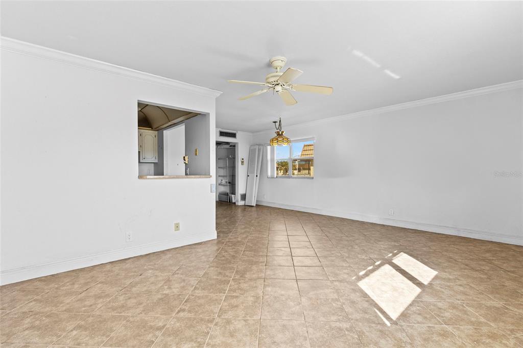 An open-concept living area features beige tile flooring, white walls, and a ceiling fan — 187 SAXONY TERRACE UNIT D, DELRAY BEACH, FL