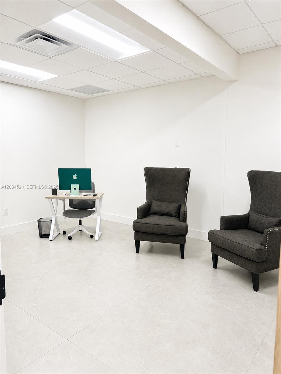 A small office features a desk with a computer and two dark gray wingback chairs — 1110 Ponce De Leon Blvd, Coral Gables FL 33134, CORAL GABLES, FL