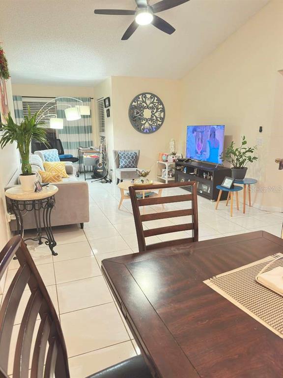 A living room with tile floors, a ceiling fan, and a dining table in the foreground — 5100 CONROY ROAD UNIT 26, ORLANDO, FL
