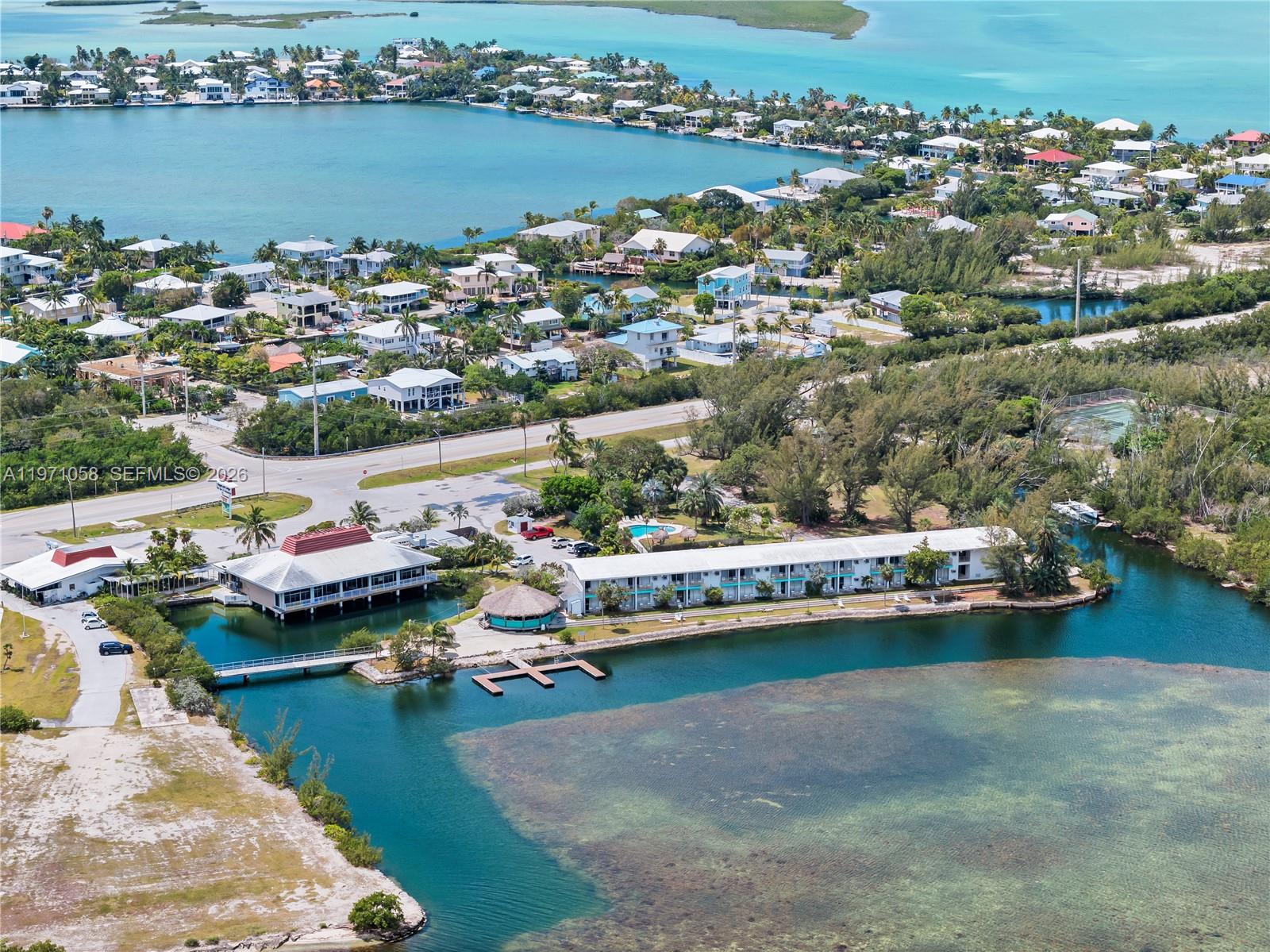 An aerial view shows a waterfront resort with a long building, pool, and boat docks — 17075 Overseas Highway, Sugarloaf FL 33042, SUGARLOAF, FL