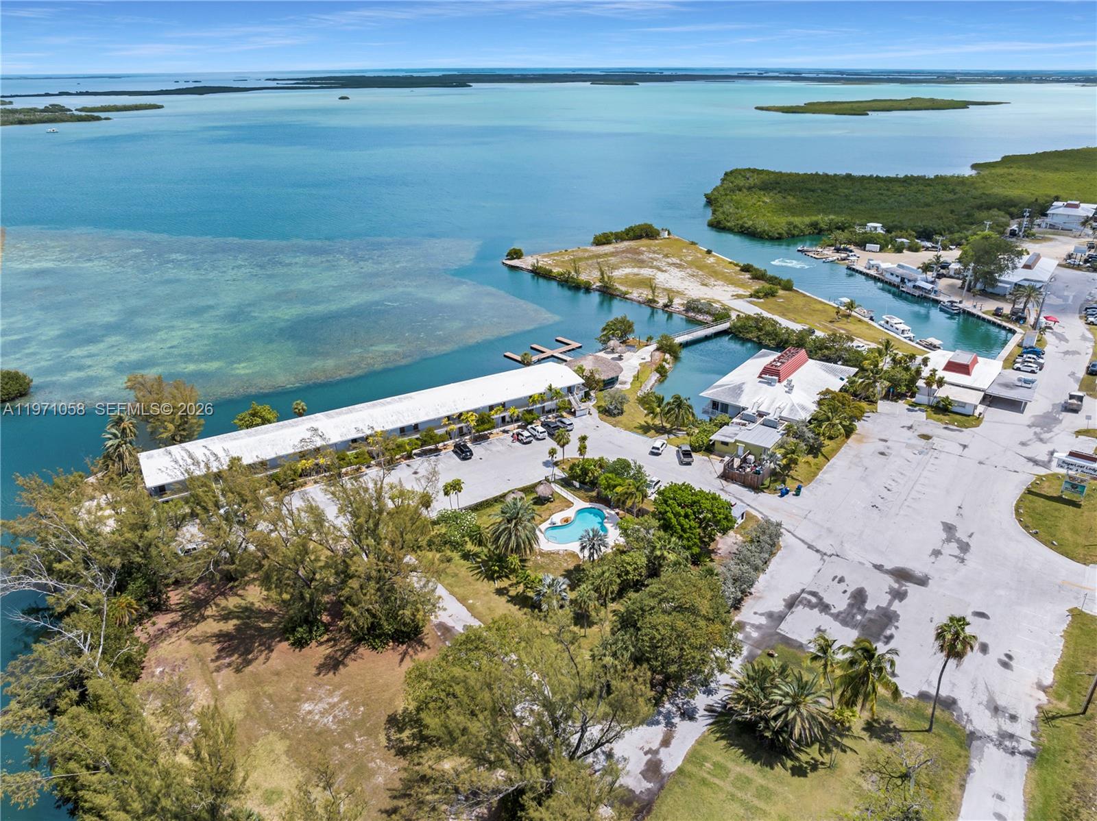 An aerial view shows a waterfront resort with a pool, parking lot, and boat docks — 17075 Overseas Highway, Sugarloaf FL 33042, SUGARLOAF, FL