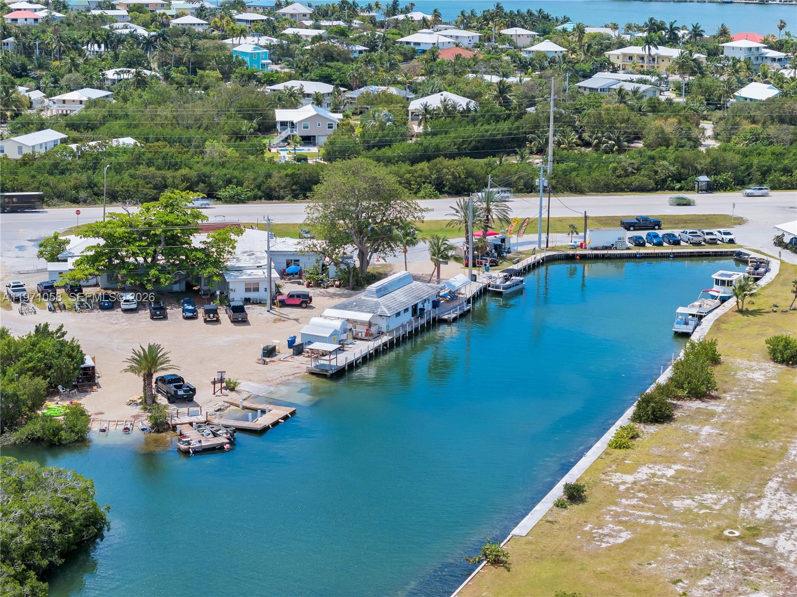 An aerial view shows a waterfront property with a boat basin, docks, and nearby buildings — 17075 Overseas Highway, Sugarloaf FL 33042, SUGARLOAF, FL