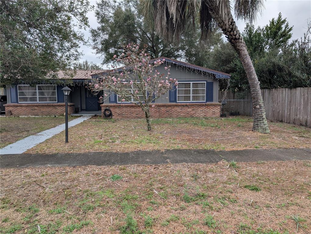 A single-story house with a brick base, gray siding, and a flowering tree in front — 2256 W GREENWAY PLACE, CITRUS SPRINGS, FL