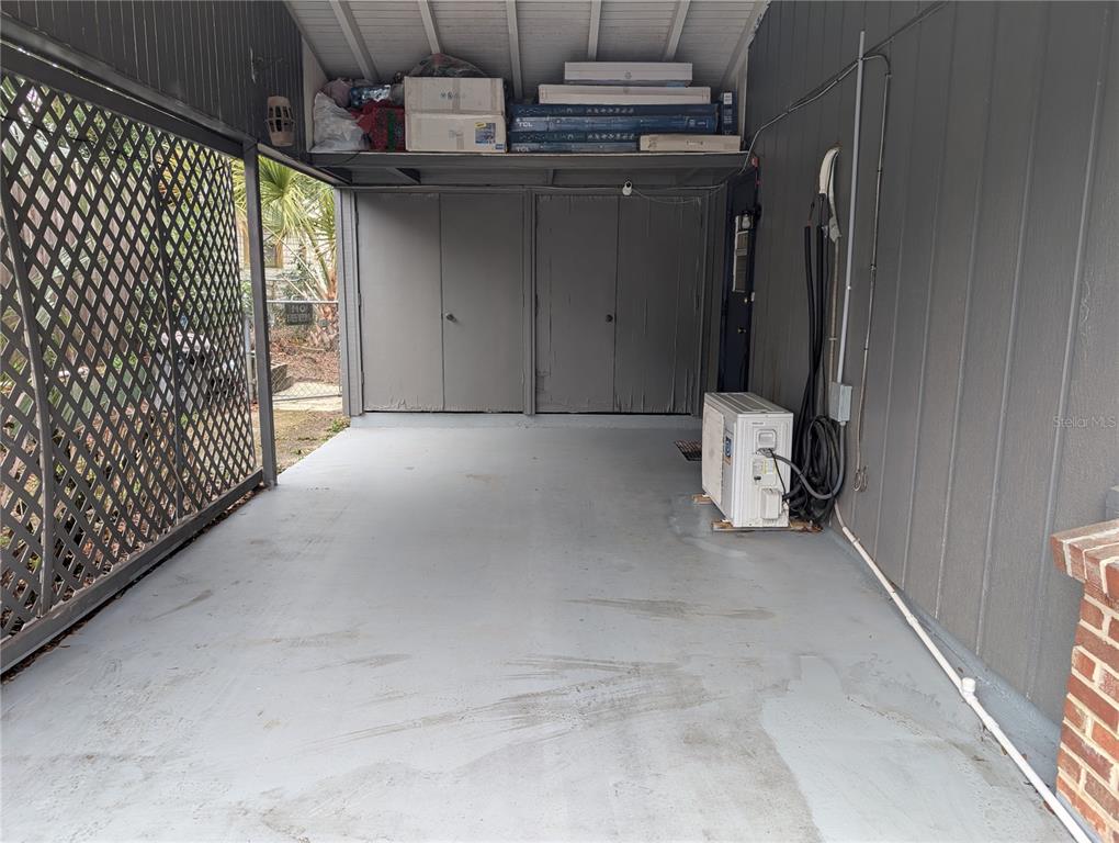 A covered carport features a concrete floor, storage cabinets, and an outdoor HVAC unit — 2256 W GREENWAY PLACE, CITRUS SPRINGS, FL