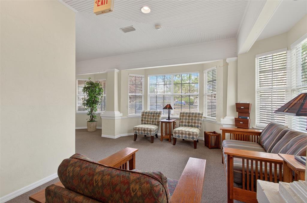 A sunroom features carpeted floors, large windows with blinds, and several pieces of wooden furniture — 1013 SW 2ND AVENUE, GAINESVILLE, FL
