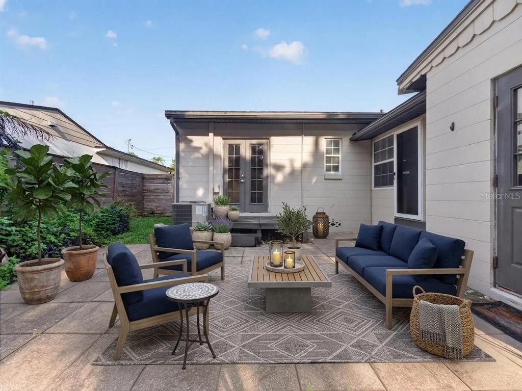 A patio features a sofa, two armchairs, a coffee table, and potted plants — 2121 IVANHOE ROAD, ORLANDO, FL