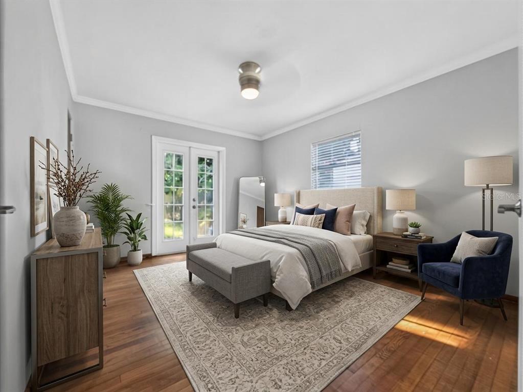 A bedroom features a bed, a blue armchair, a rug, and glass doors to the outside — 2121 IVANHOE ROAD, ORLANDO, FL