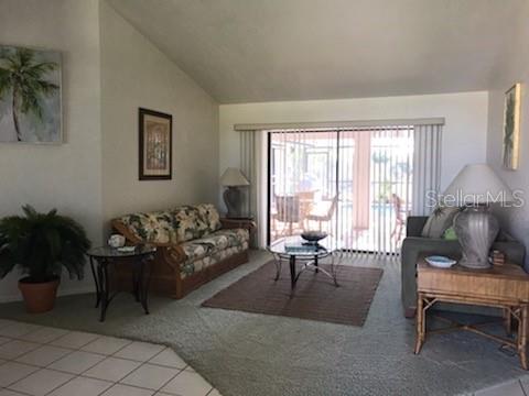A living room features a floral sofa, a glass-topped coffee table, and sliding glass doors — 7160 CARLSBAD TERRACE, ENGLEWOOD, FL