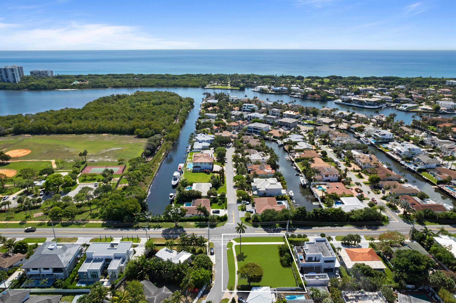 An aerial view shows a vacant residential lot situated near a canal and the ocean — 498 NE 14th Street, Boca Raton FL 33432, BOCA RATON, FL