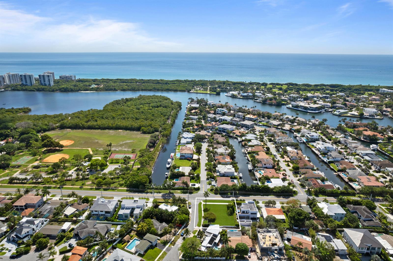 An aerial view shows a coastal neighborhood with a vacant lot, houses, and waterways — 498 NE 14th Street, Boca Raton FL 33432, BOCA RATON, FL