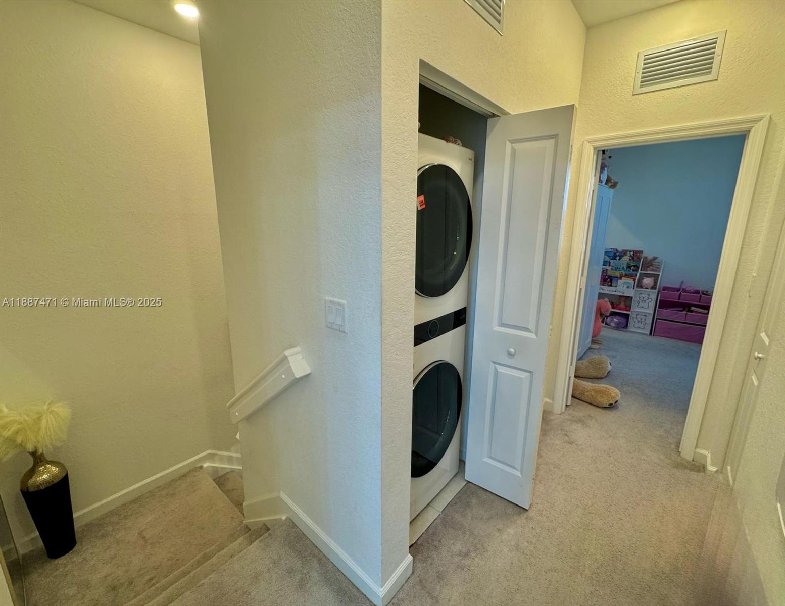 A hallway features a stacked washer and dryer unit, carpeted flooring, and a staircase — 23541 SW 127th Pl, Homestead FL 33032, HOMESTEAD, FL