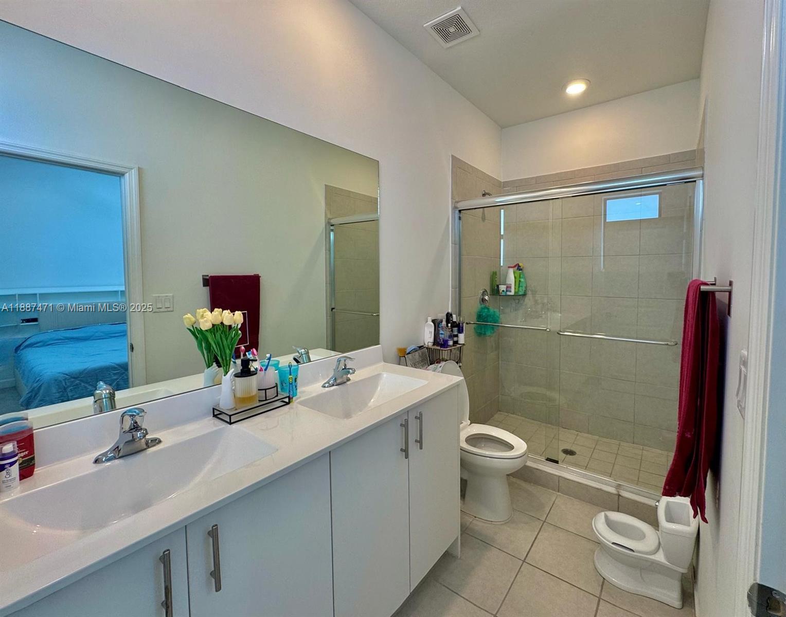 A bathroom features a double vanity, a glass-enclosed shower, and a small child-sized toilet — 23541 SW 127th Pl, Homestead FL 33032, HOMESTEAD, FL