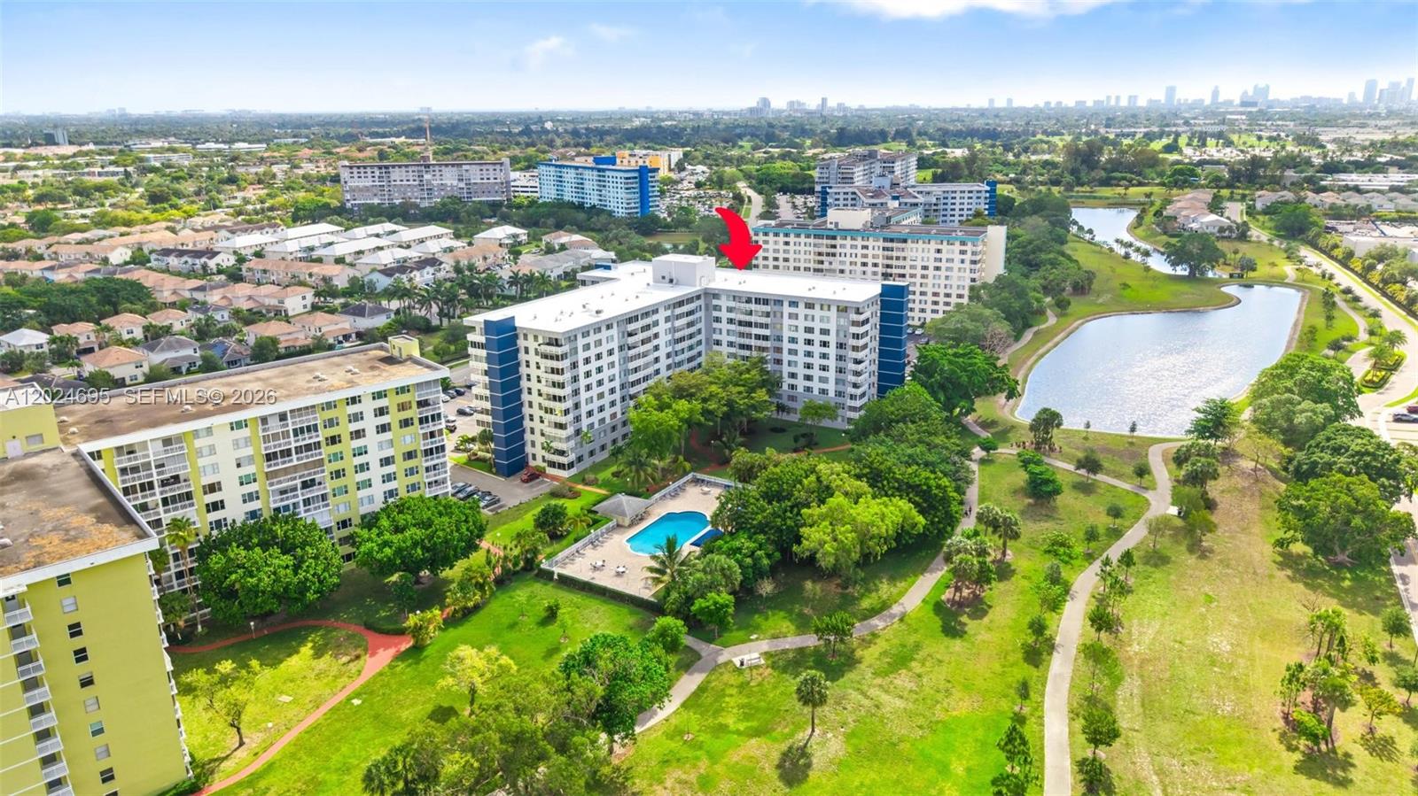 An aerial view shows multiple apartment buildings, a swimming pool, and a lake — 4350 Hillcrest Dr # 1016, Hollywood FL 33021, HOLLYWOOD, FL