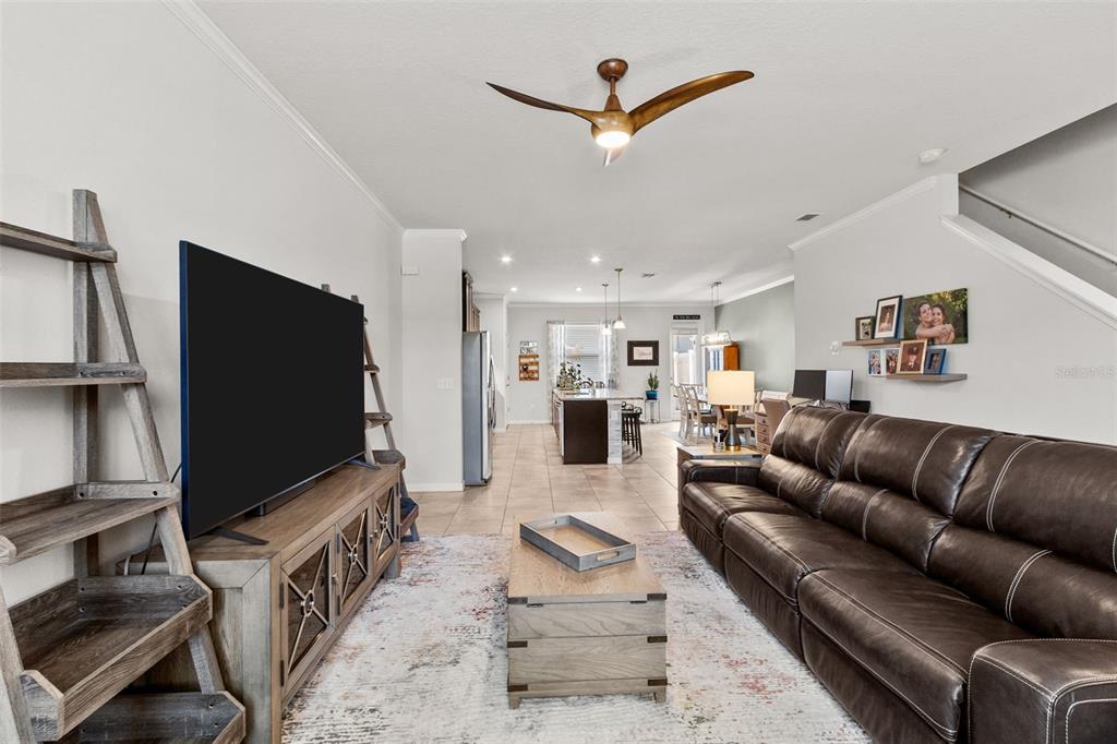 An open-concept kitchen and dining area featuring dark wood cabinets, granite countertops, and tile flooring — 2421 HEARTH DRIVE, ODESSA, FL