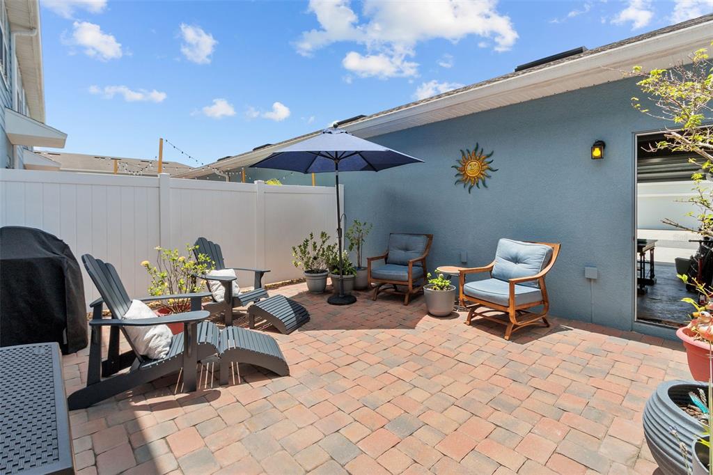 A living room with a brown leather sofa, coffee table, and an open-concept kitchen beyond — 2421 HEARTH DRIVE, ODESSA, FL