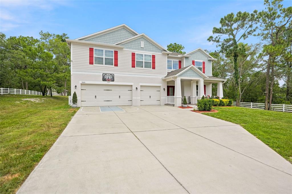 A two-story suburban house with a three-car garage and a concrete driveway — 9025 MAZETTE ROAD, WEEKI WACHEE, FL