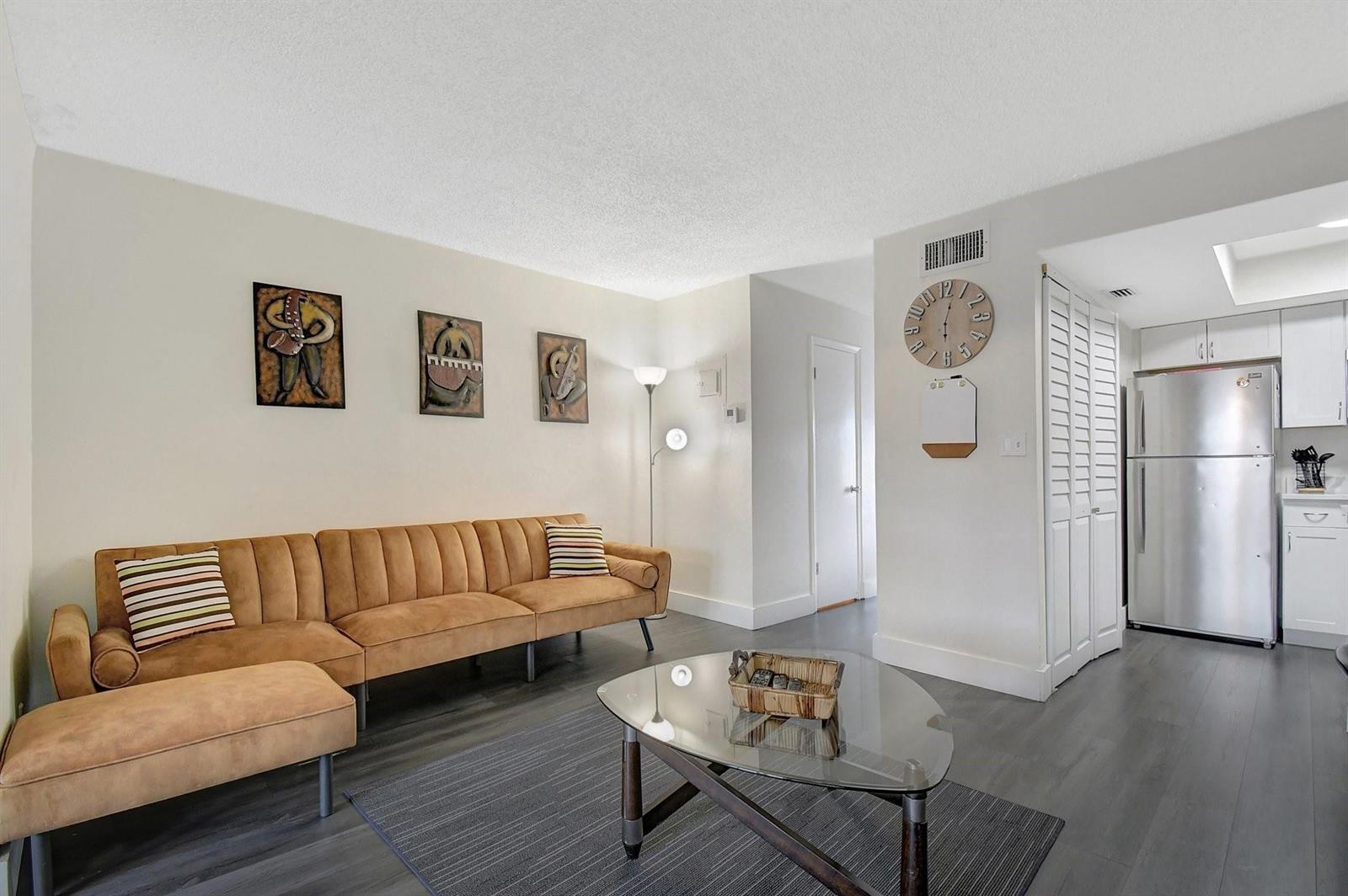 A living room features a tan sofa, glass coffee table, and gray wood-look flooring — 3708 SW 59th Terrace # 68, Davie FL 33314, DAVIE, FL