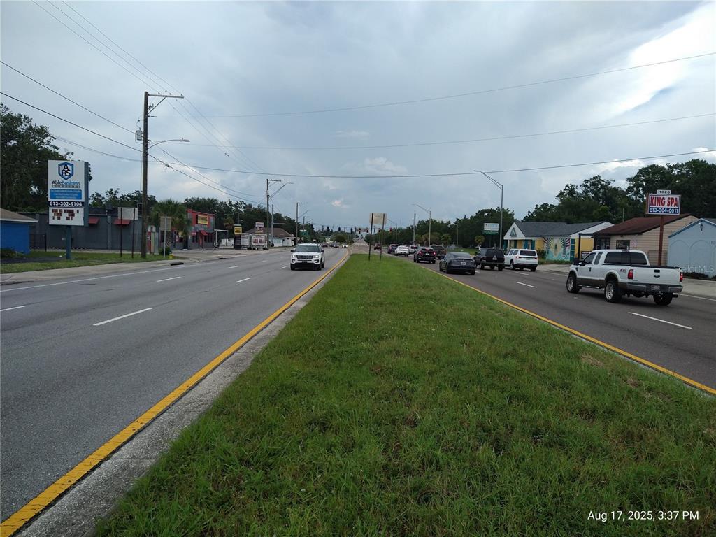 A view of a multi-lane road with a grassy median and surrounding commercial buildings — 909 and 911 WEST HILLSBOROUGH AVENUE, TAMPA, FL