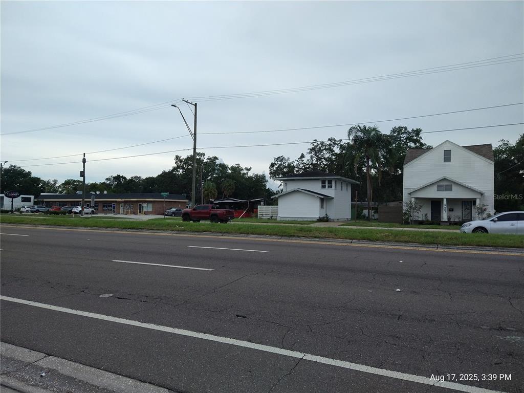 A street view shows a multi-lane road in front of a commercial building and two houses — 909 and 911 WEST HILLSBOROUGH AVENUE, TAMPA, FL