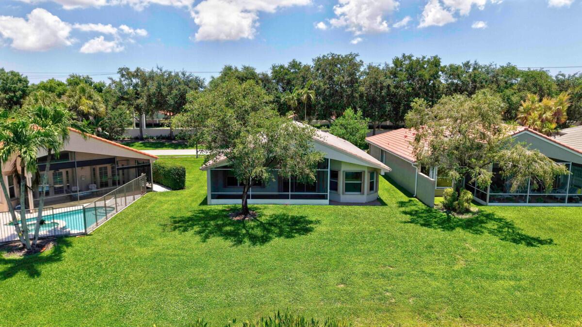 An aerial view of three suburban houses with screened-in lanais and large grassy backyards — 11709 Castellon Court, Boynton Beach FL 33437, BOYNTON BEACH, FL
