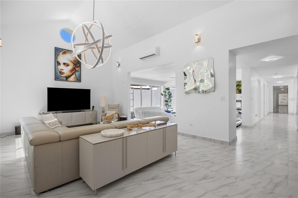 A modern living room features a large sectional sofa, a spherical chandelier, and marble flooring — 394 DORADO BEACH EAST, DORADO, PR