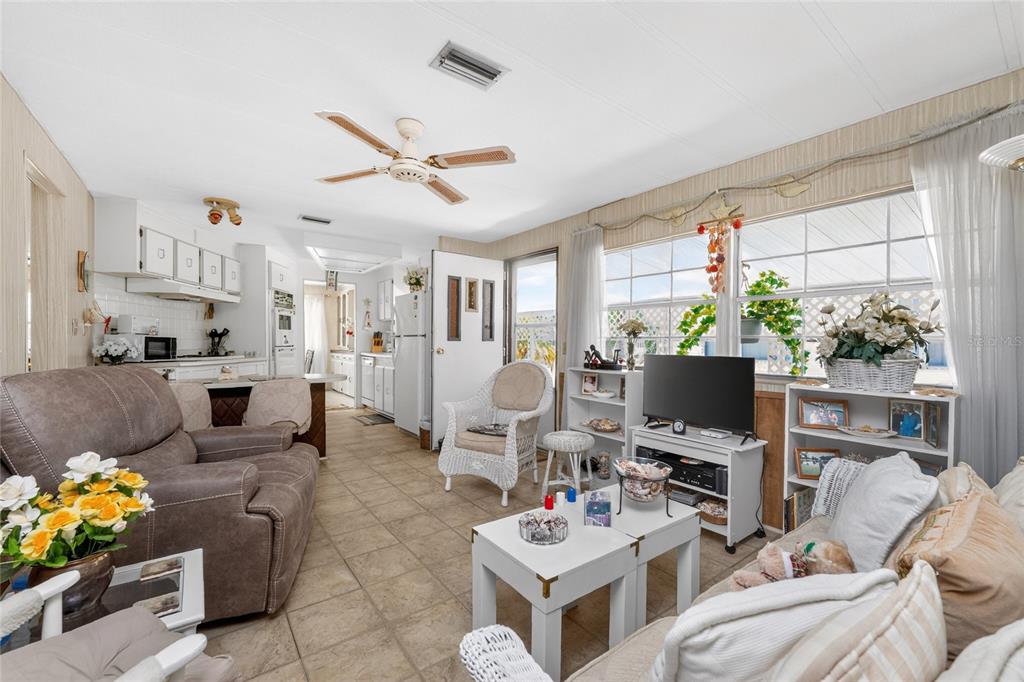 A living room with tile floors, a ceiling fan, and an open kitchen in back — 17 N FLORA VISTA STREET, ENGLEWOOD, FL