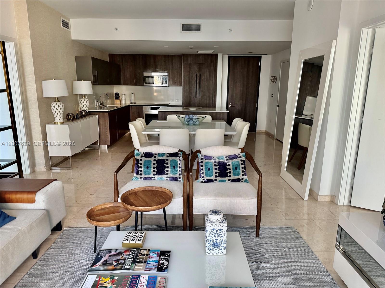 A modern open-concept living and dining area features dark wood cabinetry and light tile floors — 88 SW 7th St # 1109, Miami FL 33130, MIAMI, FL