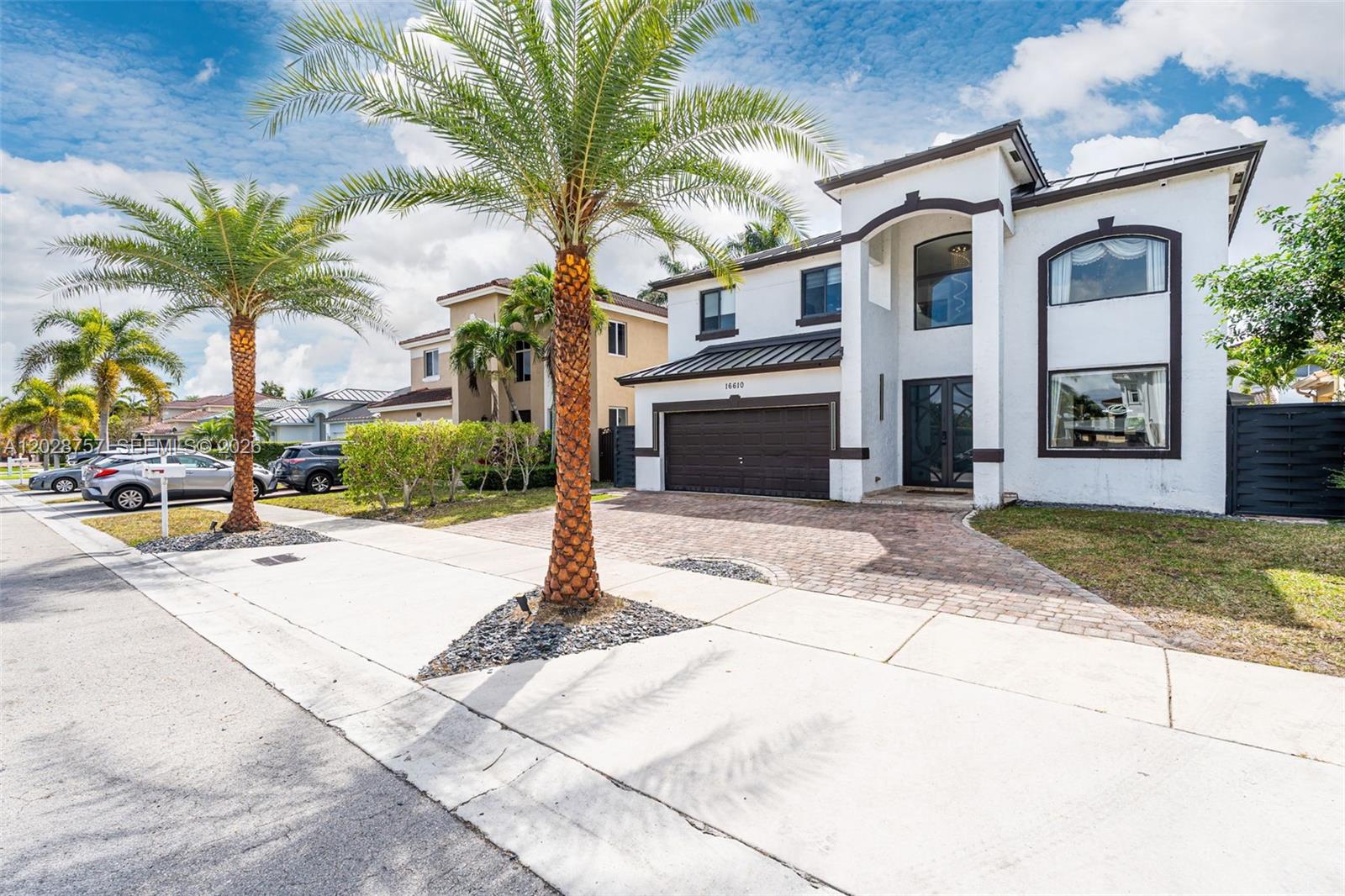A two-story white house with a brown garage and palm trees in the front yard — 16610 SW 57th Ln, Miami FL 33193, MIAMI, FL