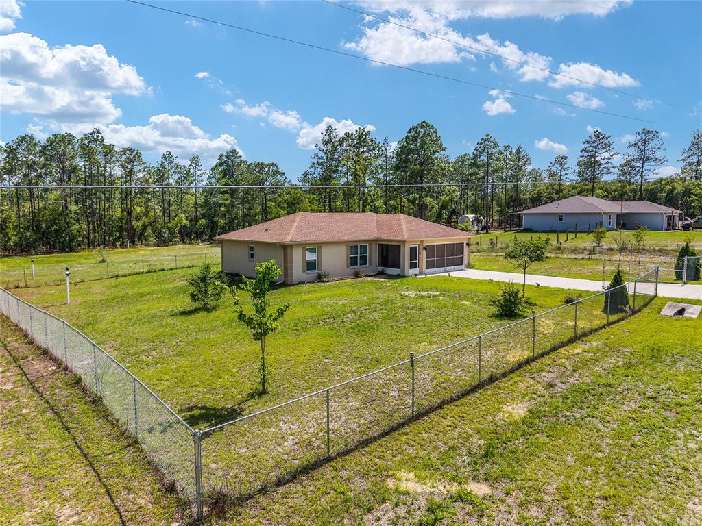 An aerial view shows a single-story house with a fenced yard and surrounding trees — 13130 SW 76TH LANE, DUNNELLON, FL