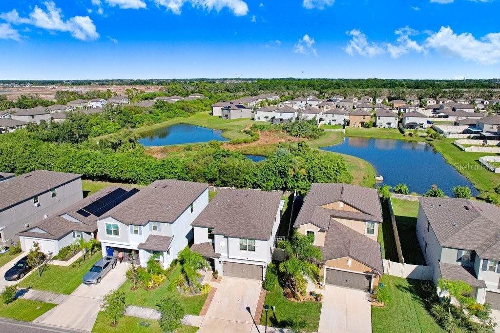 An aerial view shows suburban houses with driveways near two ponds and green landscaping — 5426 RAINWOOD MEADOWS DRIVE, APOLLO BEACH, FL