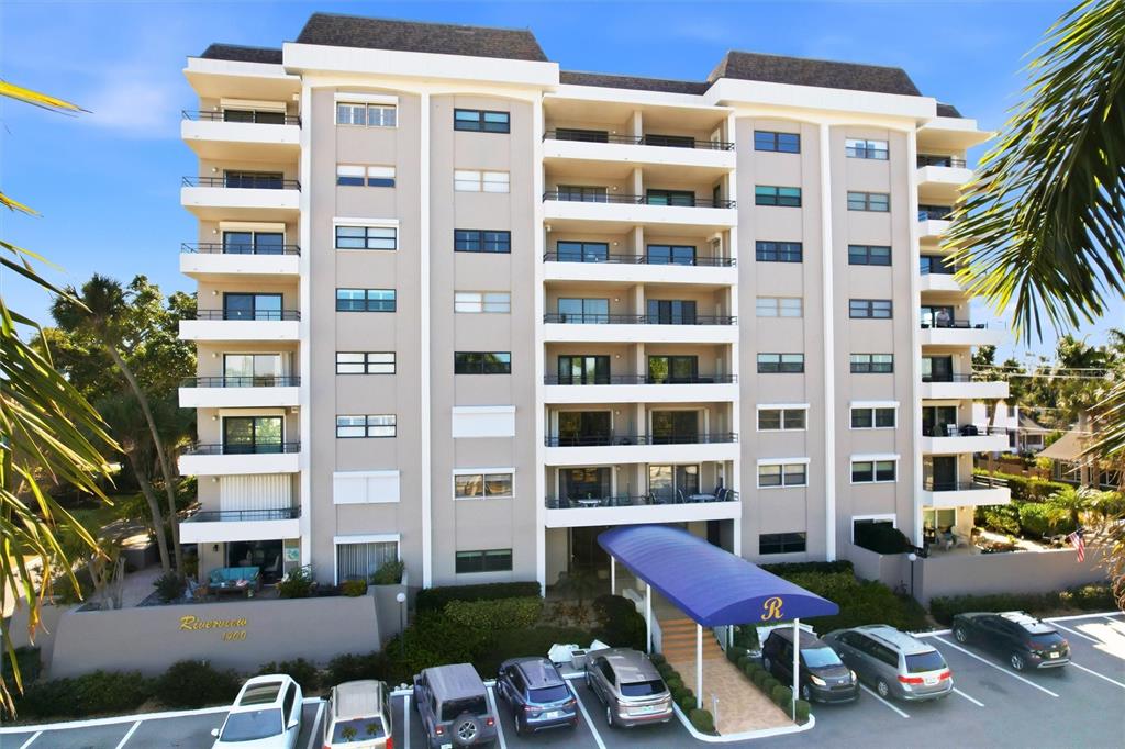 A multi-story apartment building with balconies and a blue awning over the entrance — 1400 1ST AVENUE W UNIT 203, BRADENTON, FL