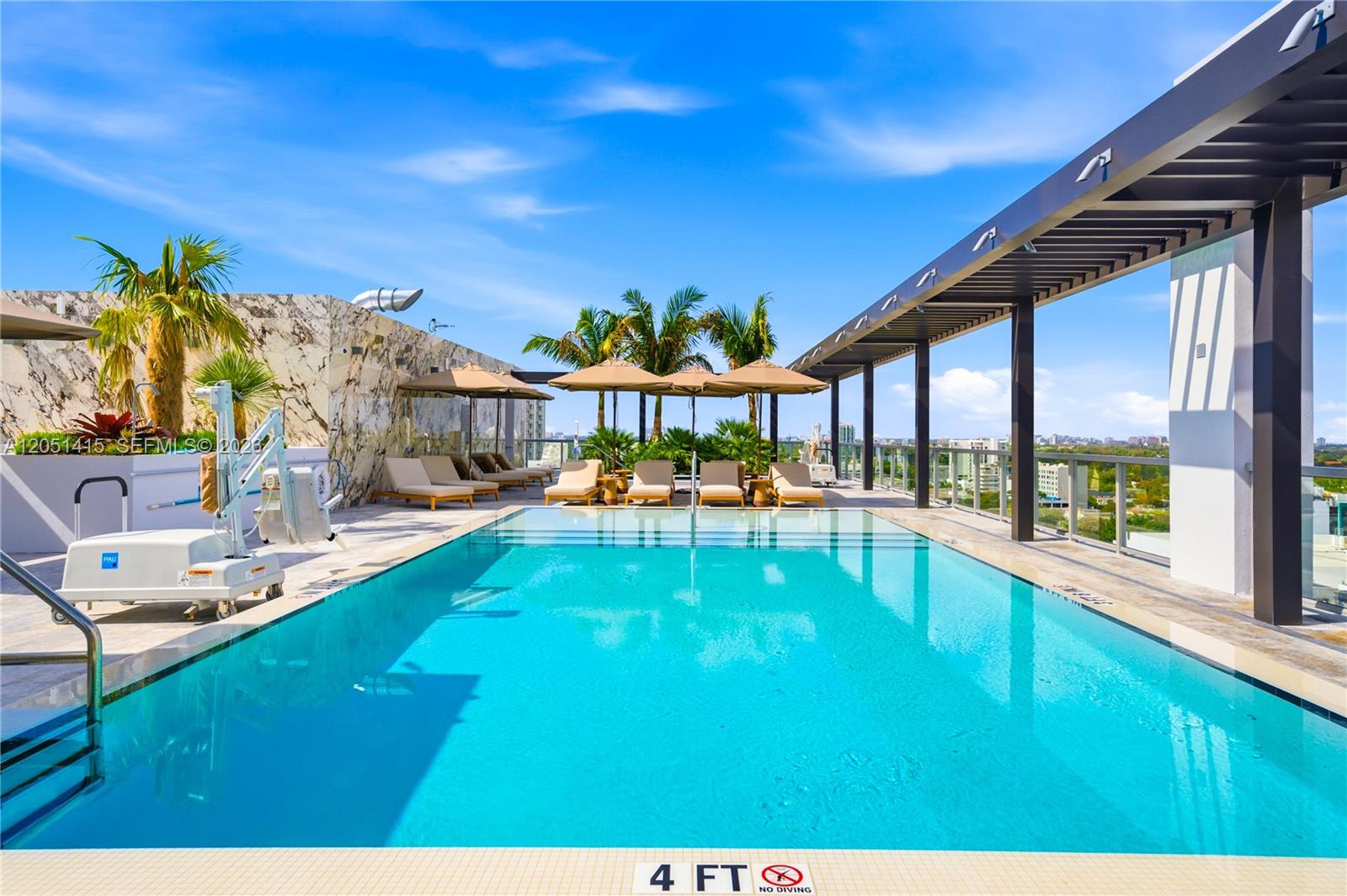 A rooftop swimming pool features lounge chairs, umbrellas, and a modern pergola under a blue sky — 1611 SW 2nd Ave # 516, Miami FL 33129, MIAMI, FL