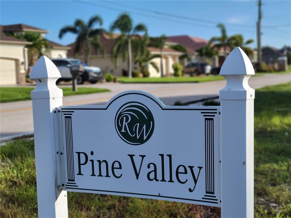 A white sign with the text Pine Valley stands in front of a residential street — 164 TOURNAMENT ROAD, ROTONDA WEST, FL
