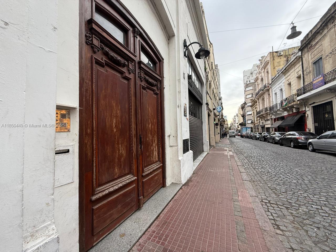 A street-level view shows a large wooden door on a cobblestone street with parked cars — 945 Defensa St San Telmo, FL 945, FL