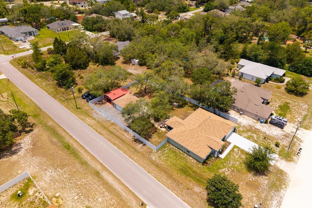 An aerial view shows a single-story house with a detached garage and fenced yard — 8343 NITTANY ROAD, WEEKI WACHEE, FL