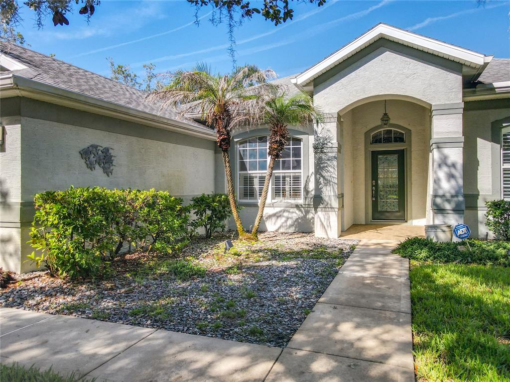 A front exterior view of a house featuring a walkway leading to the entrance — 14 EGRET DRIVE, PALM COAST, FL